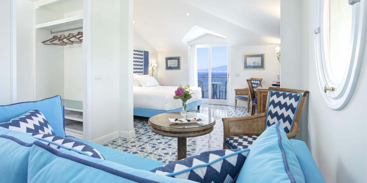 View of the full room Deluxe Junior Suite light blue furnitures and sea view daytime