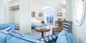 View of the full room Deluxe Junior Suite light blue furnitures and sea view daytime