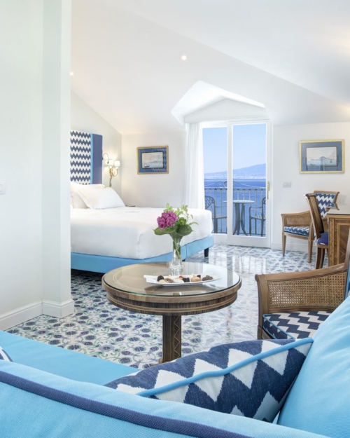 View of the full room Deluxe Junior Suite light blue furnitures and sea view daytime