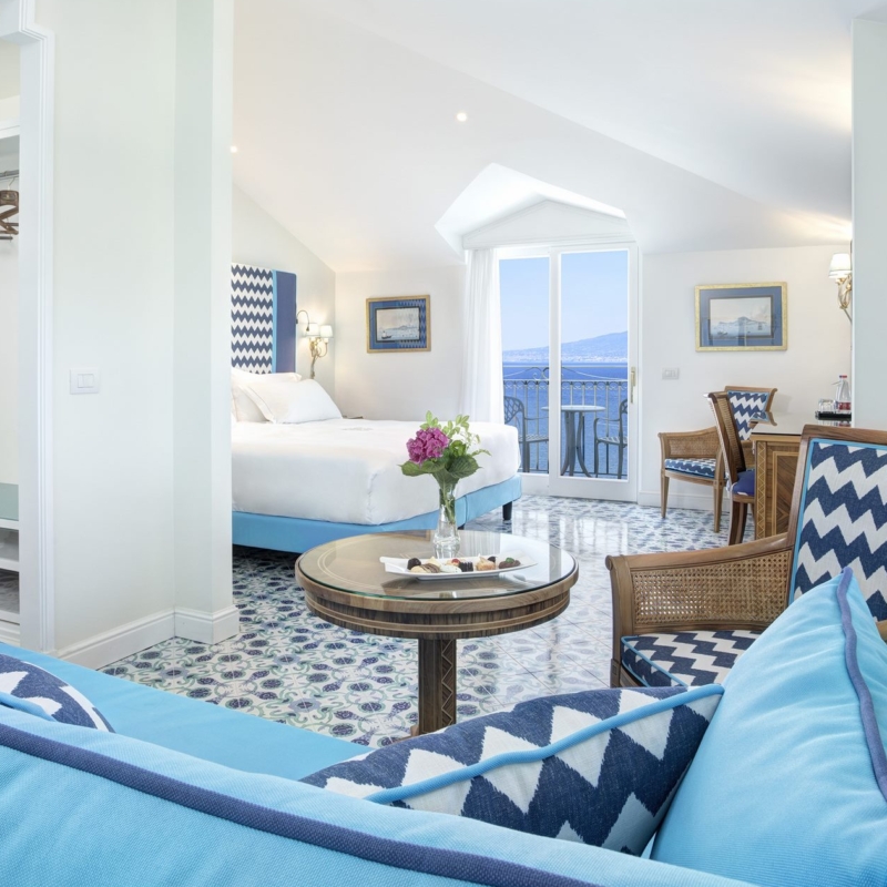 View of the full room Deluxe Junior Suite light blue furnitures and sea view daytime