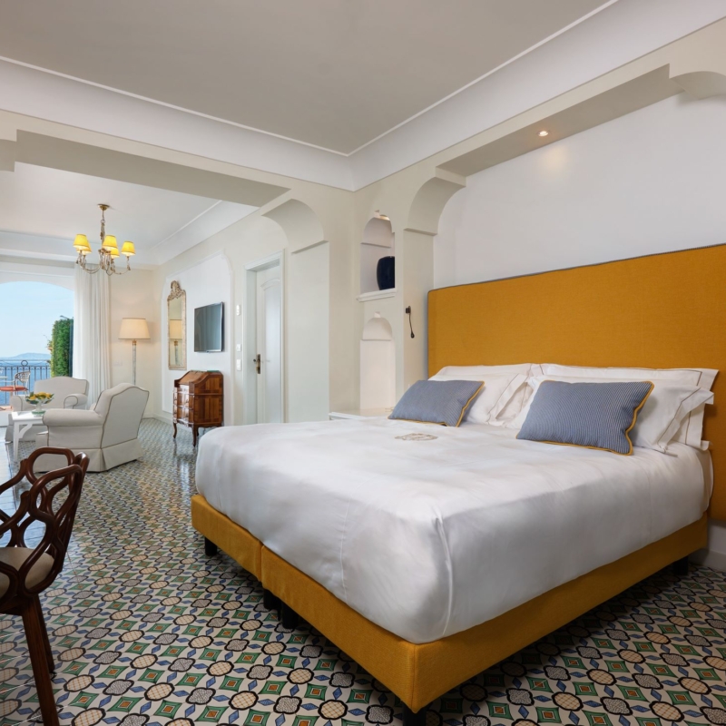 View of the Signature Suite details of the bed and the view and a chair daytime