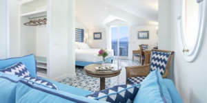 Visione completa della Deluxe Junior Suite con rifiniture azzurre e verdi vista mare di giorno
